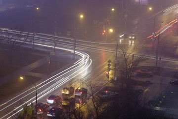 traffic on the streets of the city at night in the fog