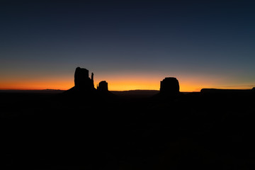 Silhouette photo of famous Buttes at the first rays of dawn light of Monument Valley on the border between Arizona and Utah, USA