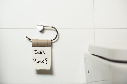 Finished toilet paper roll with a Don't panic sign - Panic because of the coronavirus concept