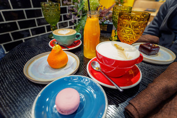 High calorie breakfast with coffee and sweets on the table in cafe