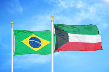 Brazil and Kuwait two flags on flagpoles and blue cloudy sky