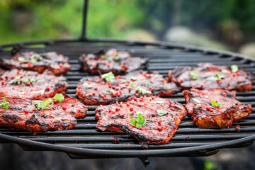 Fresh and spicy pork neck with spices on a grill