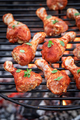 Raw and spicy chicken legs with spices on grill