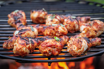 Tasty and spicy grilled chicken leg with spices on grill
