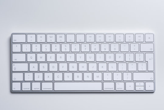 Computers. White minimalistic aluminium keyboard on a white table. Closeup