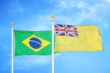 Brazil and Niue two flags on flagpoles and blue cloudy sky