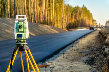 Surveyors equipment (theodolite or total positioning station) on the construction site of the road...