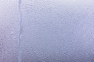 Moisture drops and water lane on glass close up background