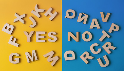 Word yes and no surrounded by letters of the alphabet on a blue and yellow background