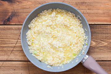 Step by step cooking risotto with vegetables, step 3 - cooking rice, top view, selective focus