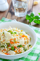 Italian risotto with vegetables - peas, beans, carrots, peppers on a white plate, selective focus
