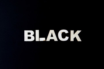 Black background with the word black with white woods letters