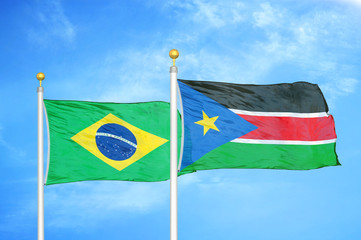 Brazil and South Sudan two flags on flagpoles and blue cloudy sky