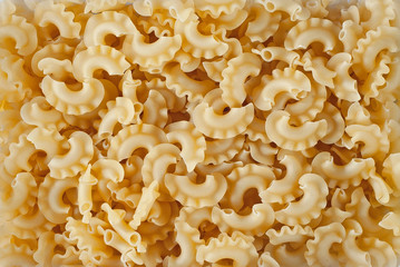 Pasta texture. Many yellow pasta are piled on the pile.