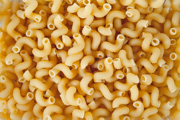 Pasta texture. Many yellow pasta are piled on the pile.