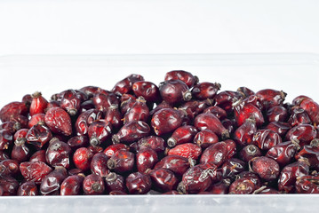 Texture of red rose hips. A lot of dried rose hips on the pile.