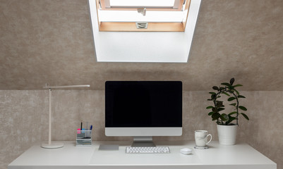 office desk with monitor, table lamp and coffee mug. working home. coffee break. horizontal image. selective focus