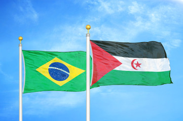 Brazil and Western Sahara two flags on flagpoles and blue cloudy sky