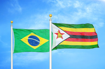 Brazil and Zimbabwe two flags on flagpoles and blue cloudy sky