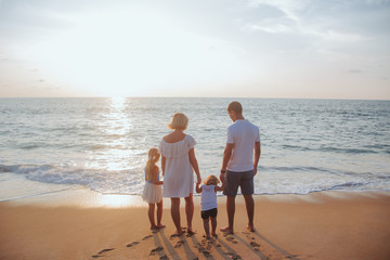 Holiday travel concept, Summer vacations. Happy family are having fun on a tropical beach in sunset.