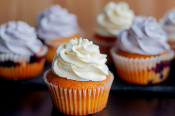 Colorful cupcakes with caramel inside and cream ontop