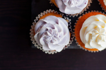 Colorful cupcakes with caramel inside and cream ontop