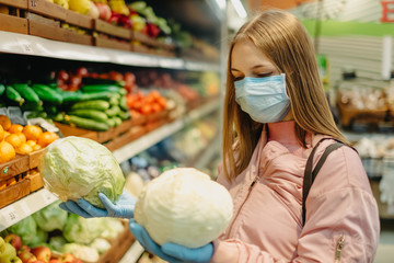 Young girl in medical masks makes purchases in a supermarket in search of food.