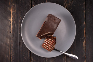Puff chocolate cake and spoon. A broken piece of chocolate cake and a fork.