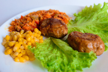 Fried chicken cutlet with potato slices served with tomato cherry and corn salad. Traditional belorussian food - roasted minced meat and potato