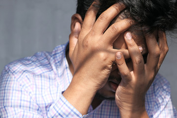 Fototapeta premium Sad unhappy man hand over face, close up