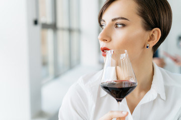 Young woman with glass of red wine close up