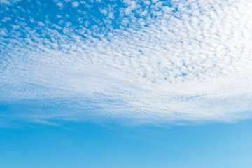 Obraz na płótnie Canvas spring blue sky with fluffy clouds moved by the wind