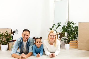 Fototapeta na wymiar Cheerful couple and their daughter staying at home