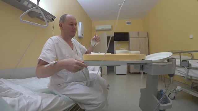 Multifunctional medical furniture makes it easier for a disabled patient to survive. The patient receives a drip and takes the food adjusting the height of the electric bed for his convenience.