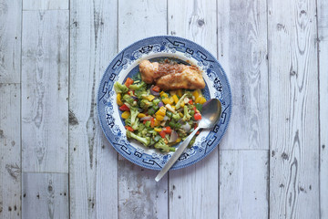 top view of homemade salad and fish fillet in a plate