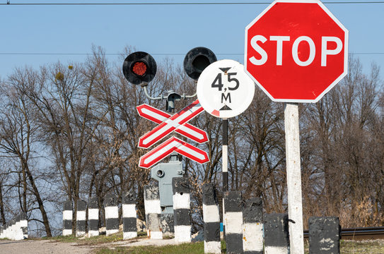 The Stop Sigh And Red Traffic Light In Front Of A Crossing Railway