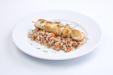 chicken kebab with buckwheat on the white plate