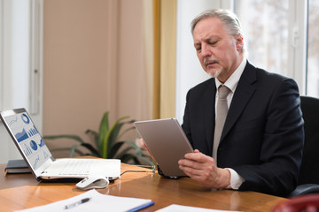 Senior businessmanusing tablet