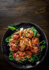 Fresh salad plate with shrimp, tomato, spinach, cabbage and Tangerine Jam in plate on wooden table background