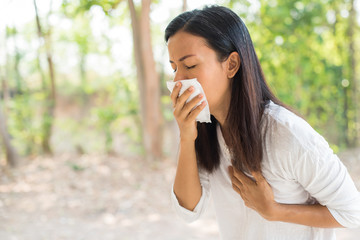 middle-aged women with cold blowing her runny nose with tissue. portrait asian middle-aged women get sick sneezing from flu, allergy symptoms coughing holding napkin. healthcare and medical concept.
