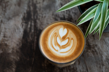 Close up a glass cup of Latte art coffee on wooden table