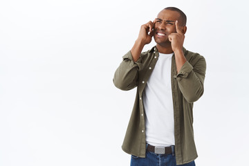 Portrait of young displeased and annoyed african-american man feel sick or uneasy, squinting touching temples, grimacing painful feeling, have headache or migraine, looking up distressed