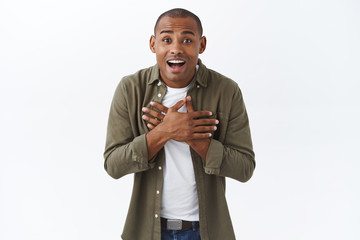 Portrait of happy surprised african-american man look with disbelief and amazement at camera,...