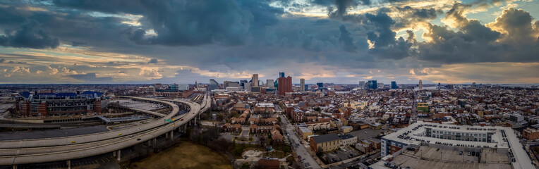 Aerial panorama of Baltimore downtown with I-395 highway, Sharp Leadenhall, Riverside, Otterbein, Federal Hill neighborhoods with dramatic sunset sky in Maryland United States