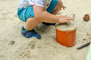 toddler child playing in the sand.