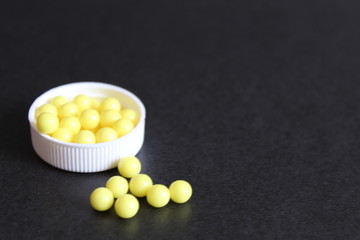 vitamins and tablets in a white cover on black background