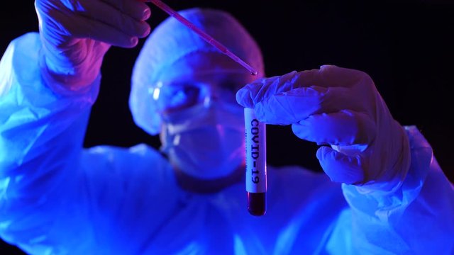 Doctor drips liquid into Covid-19 test tube