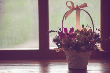 Cute basket with roses, flower arrangement on the windowsill, side view