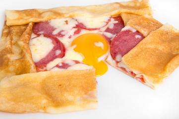 Large pancake with tomatoes and smoked sausage drenched in cheese and egg