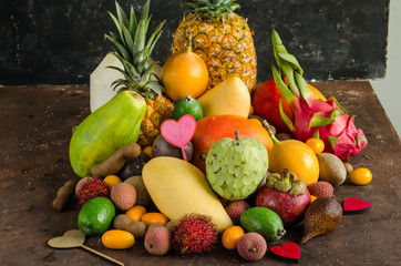 Healthy eating, varieity of tropical fruits on a dark background.